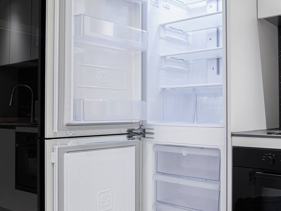 A modern kitchen with a built-in refrigerator, a microwave, and a stove.