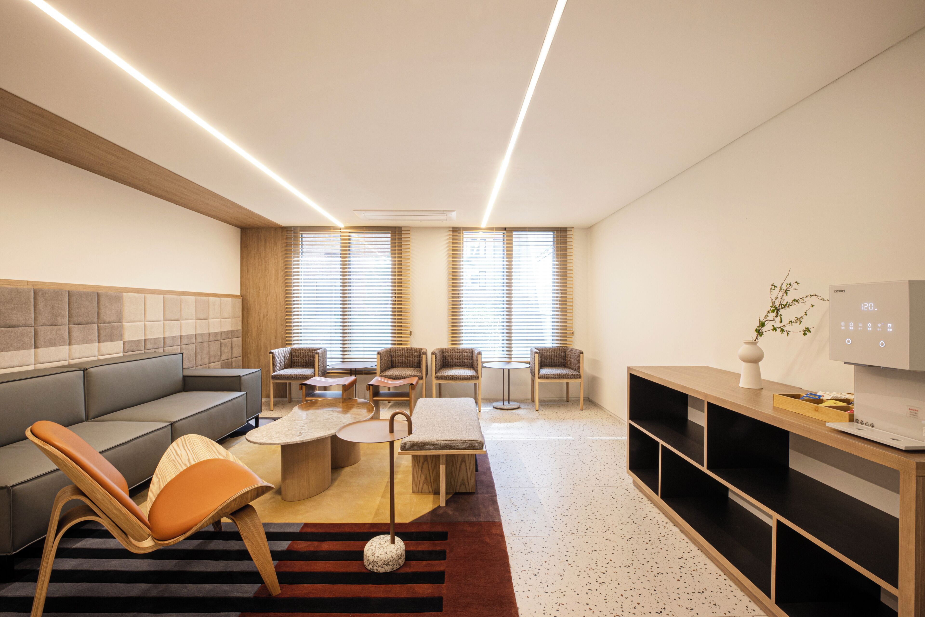 A modern living room with a sofa, chairs, a coffee table, and a TV stand.