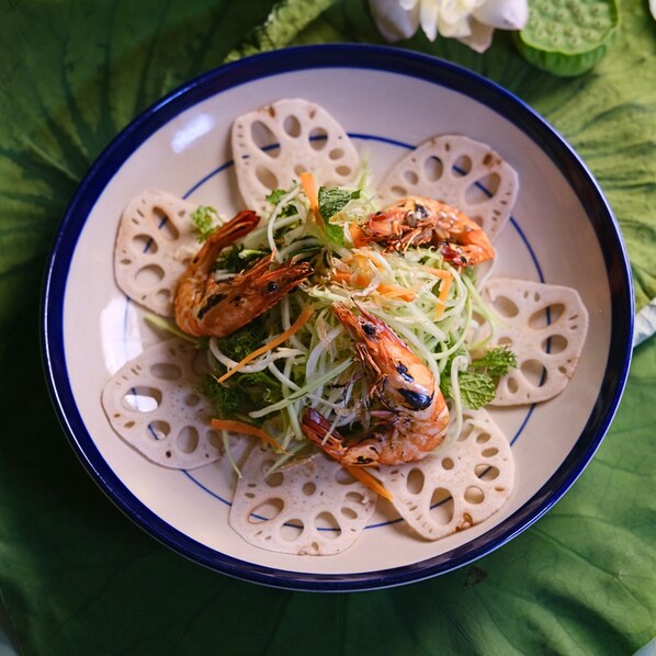 A plate of food with shrimp and vegetables on a blue and white plate.