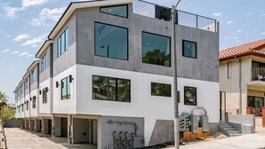 A modern multi-story building with large windows and a flat roof. - Stylish Modern Home, Private Rooftop & City Views! (Los Angeles)