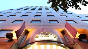 Een moderne hotelentree met een opvallend bord waarop 