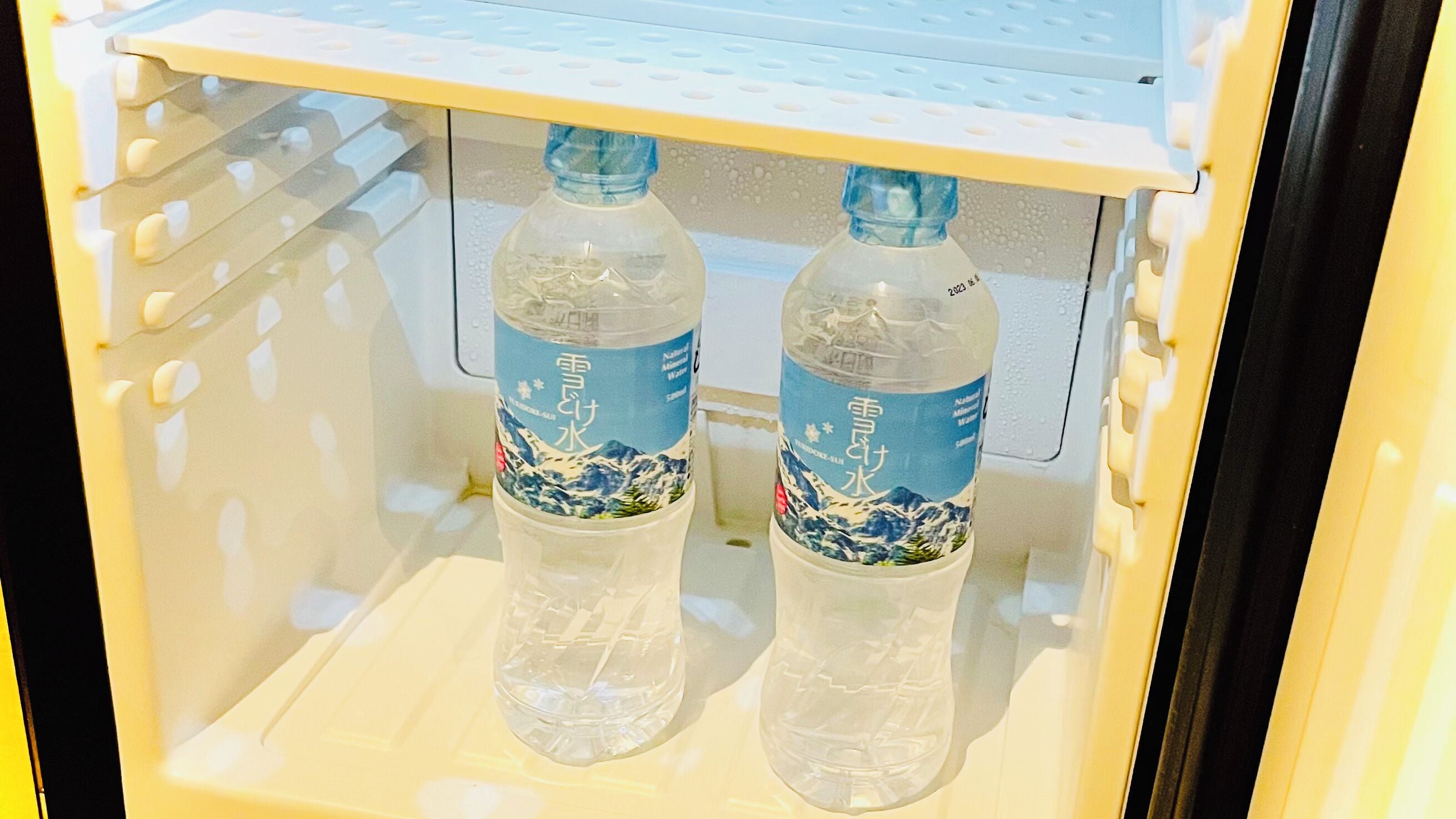 Un refrigerador con dos botellas de agua.