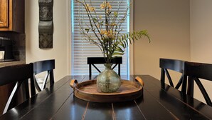 Ein Esstisch mit Blumen in einer Vase, einer Holztablett und Stühlen.