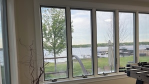 A room with large windows overlooking a body of water, a foosball table, and a potted plant. - Fully renovated lake front home
on Delavan’s North Shore (Delavan)