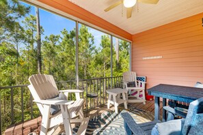 Un espace extérieur abrité comprenant deux fauteuils Adirondack, une petite table et un banc.