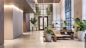 A modern lobby with a reception desk, large windows, and potted plants. - 4805 - Charming Penthouse w Views & Style, Pool & Gym in vibrant Miami (Miami)