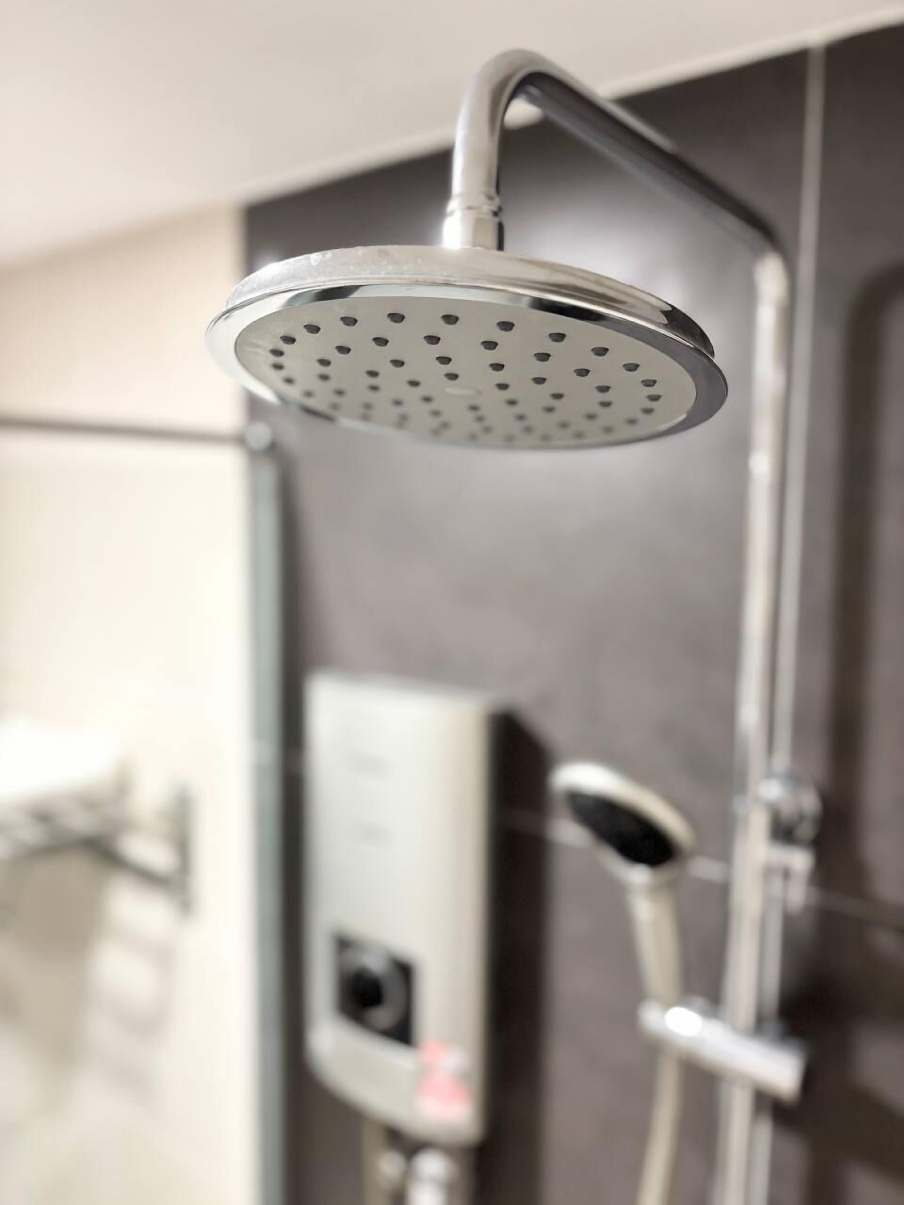 Un cabezal de ducha moderno con panel de control y una ducha de mano.