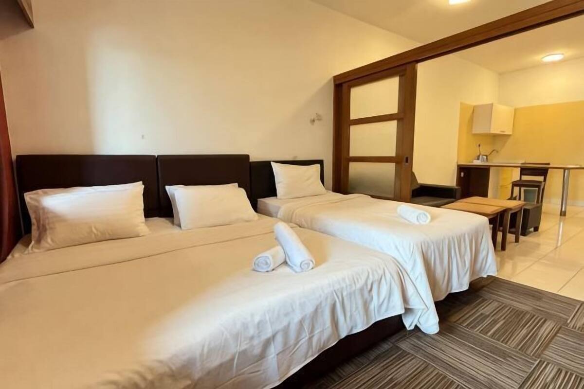 Habitación de hotel con dos camas, un escritorio y una silla.