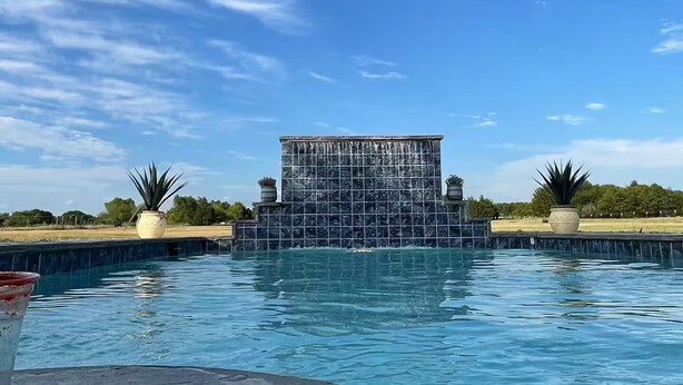 A swimming pool with a tiled structure in the background. - Skyblue Ranch, Peaceful Getaway with Pool!Pets! (Terrell)