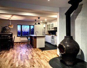 Enjoy cooking in this well-equipped kitchen with a central island, oven, and large window offering a view of the outdoors.