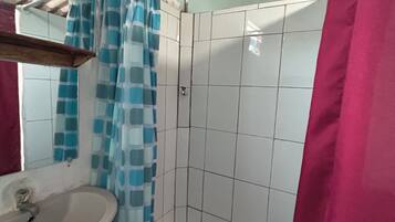 Een douche, handdoeken, zeep, toiletpapier