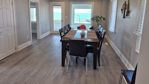 A dining area with a large table, chairs, and a view of the outdoors. - The Marylin Lakehouse (Private Long Dock & Boat Ramp) (Lincoln)