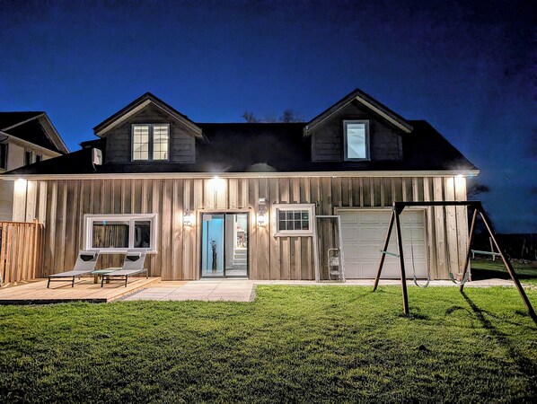 A two-story house with a garage, a covered patio, and a swing set in the yard. - The Marylin Lakehouse (Private Long Dock & Boat Ramp) (Lincoln)