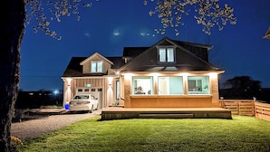 A two-story house with a well-lit front porch and a garage. - The Marylin Lakehouse (Private Long Dock & Boat Ramp) (Lincoln)