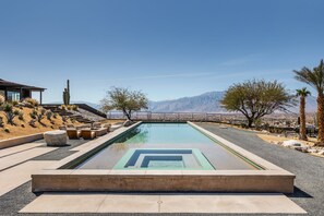 A swimming pool with a geometric design, surrounded by a landscaped area with desert plants and a mountain view. - Addendum Estate - 2 Pools, Panoramic Views & Luxe Privacy for Groups (Desert Hot Springs)