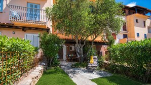 Un patio con un sendero de piedra, un árbol y una silla.