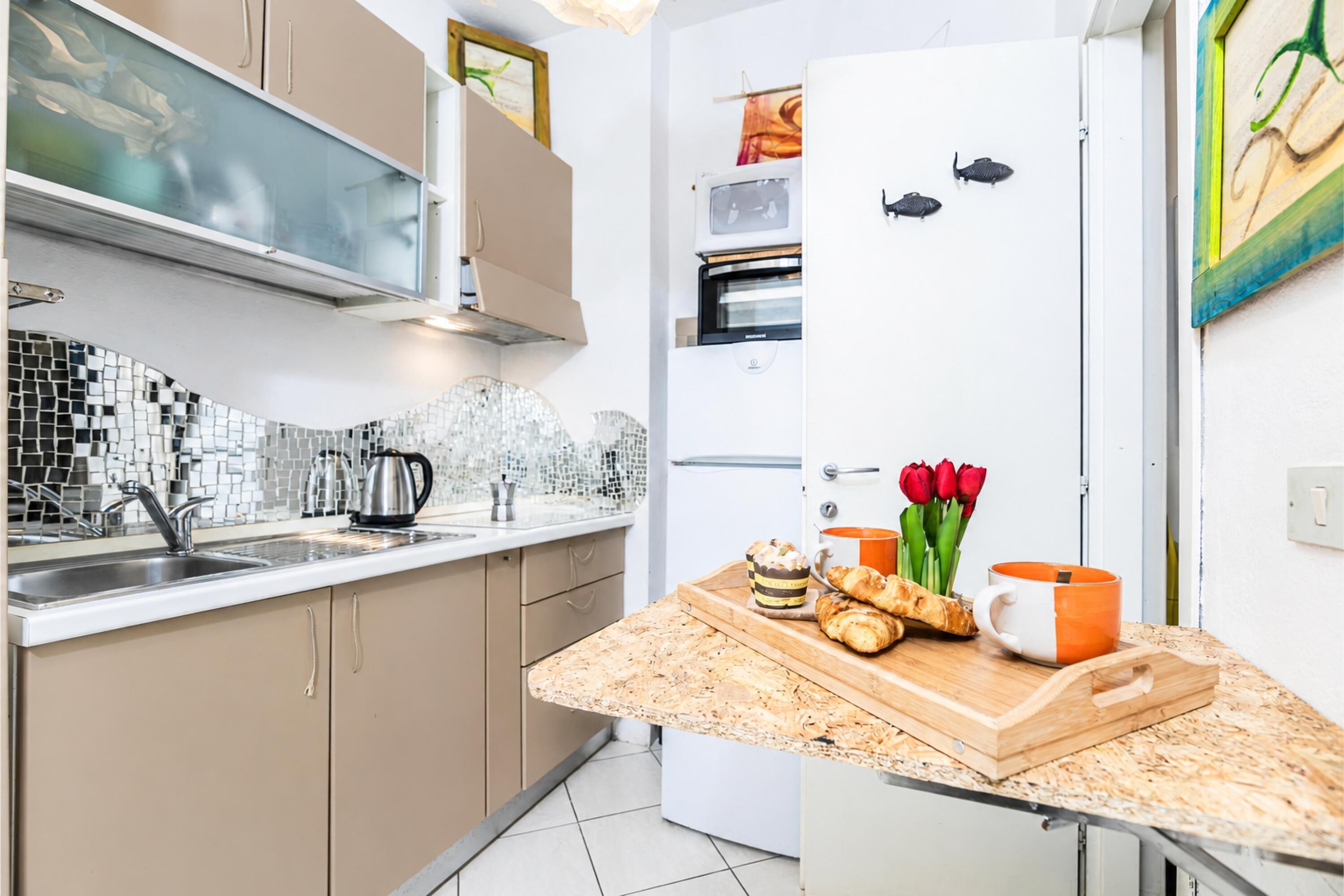 A modern kitchen with a built-in oven, a microwave, and a refrigerator.