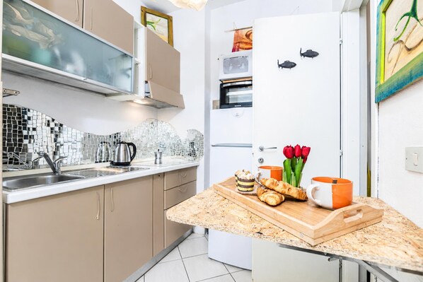 A modern kitchen with a built-in oven, a microwave, and a refrigerator.