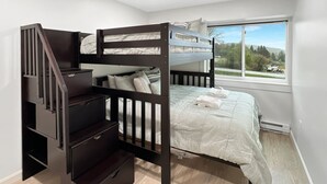 A bedroom with a bunk bed, a staircase with storage, a large window with a view, and a white wall. - Newly Remodeled 1BR | Shuttle, Fireplace, Amenities in the Heart of Killington (Killington)