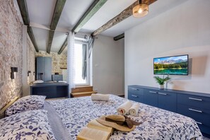 A bedroom with a bed, a TV, a dresser, and a window with curtains. - Villa Galant with Pool and Sauna, Maružini, Croatia (Maružini)