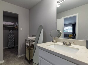 A modern bathroom with a sink, mirror, and towel rack. - Montrose Chic Studio! Medical Center 12 (Houston)