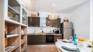 Een moderne keuken met houten planken, een eettafel gedekt voor twee personen, en een groot raam.
