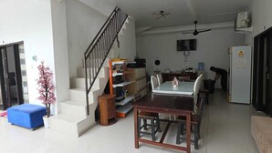 A spacious living area with a dining table, a staircase, and a kitchen area. - Ceria House Ungasan Uluwatu  (Ungasan)