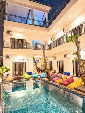 A multi-level indoor swimming pool with a glass bottom, surrounded by colorful bean bags and a staircase. - Ceria House Ungasan Uluwatu  (Ungasan)