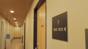 A hotel corridor with a sign indicating room numbers BW207 and BW218. - Brightwood Hotel & Residences (Manila)
