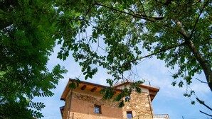 A stone building with a wooden balcony and a staircase leading to the entrance. - Poderi Alugi Serravalle by Interhome (Piasco)