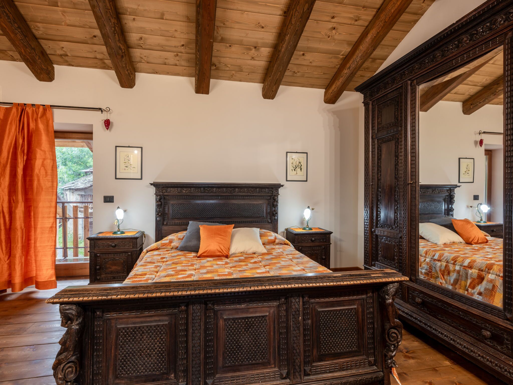 Quarto com uma cama grande, cabeceira de madeira e um espelho.