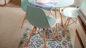 A dining area with a round table, four chairs, and a hanging light fixture. - The Retro Apartment in Revere with outdoor area (Revere)