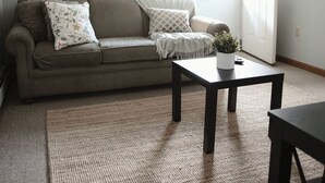 A living room with a ceiling fan, a sofa, a coffee table, and a rug. - The Retro Apartment in Revere with outdoor area (Revere)