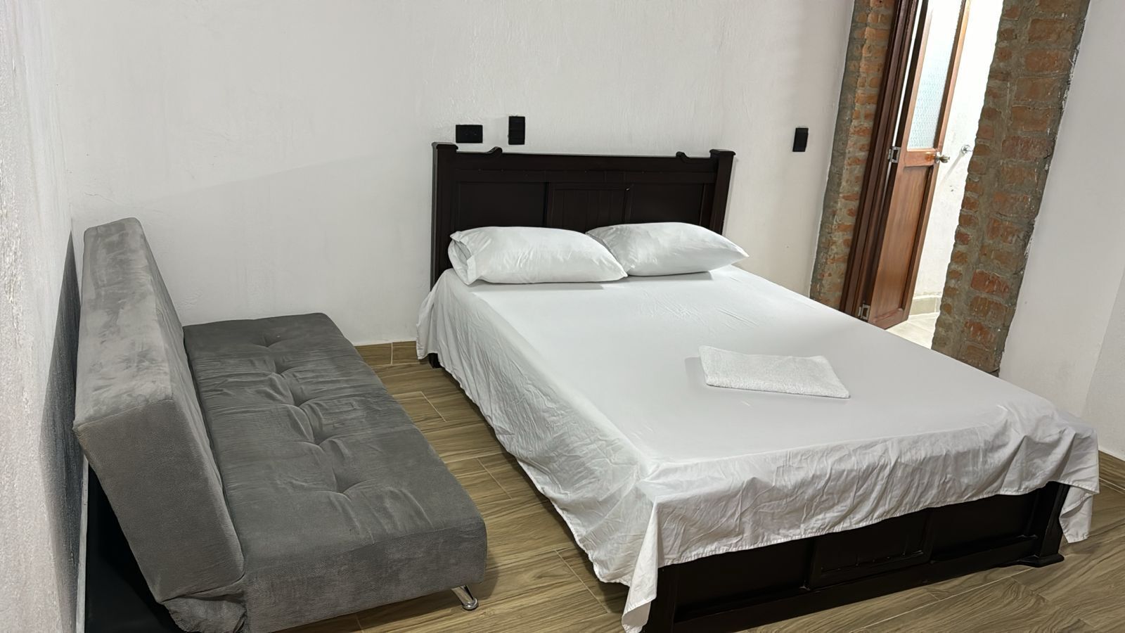 Un dormitorio con una cama, un banco y una ventana.