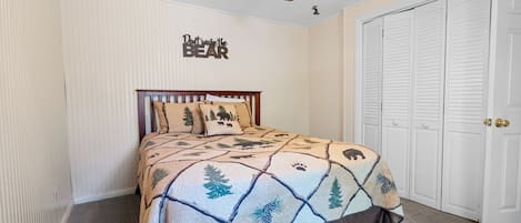 Un dormitorio con cama, ventilador de techo y armario.