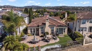 A residential area with a house featuring a patio with outdoor furniture, a swimming pool, and a hilly landscape in the background. - Spacious w/ Yard, BBQ, Presidio Access Near Park, Pool, Tennis, Beaches & Legoland! Extended Stays (Carlsbad)