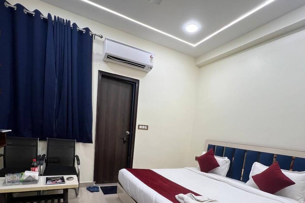 Une chambre d’hôtel équipée d’un lit, d’un bureau, d’une télévision et d’un appareil de climatisation.
