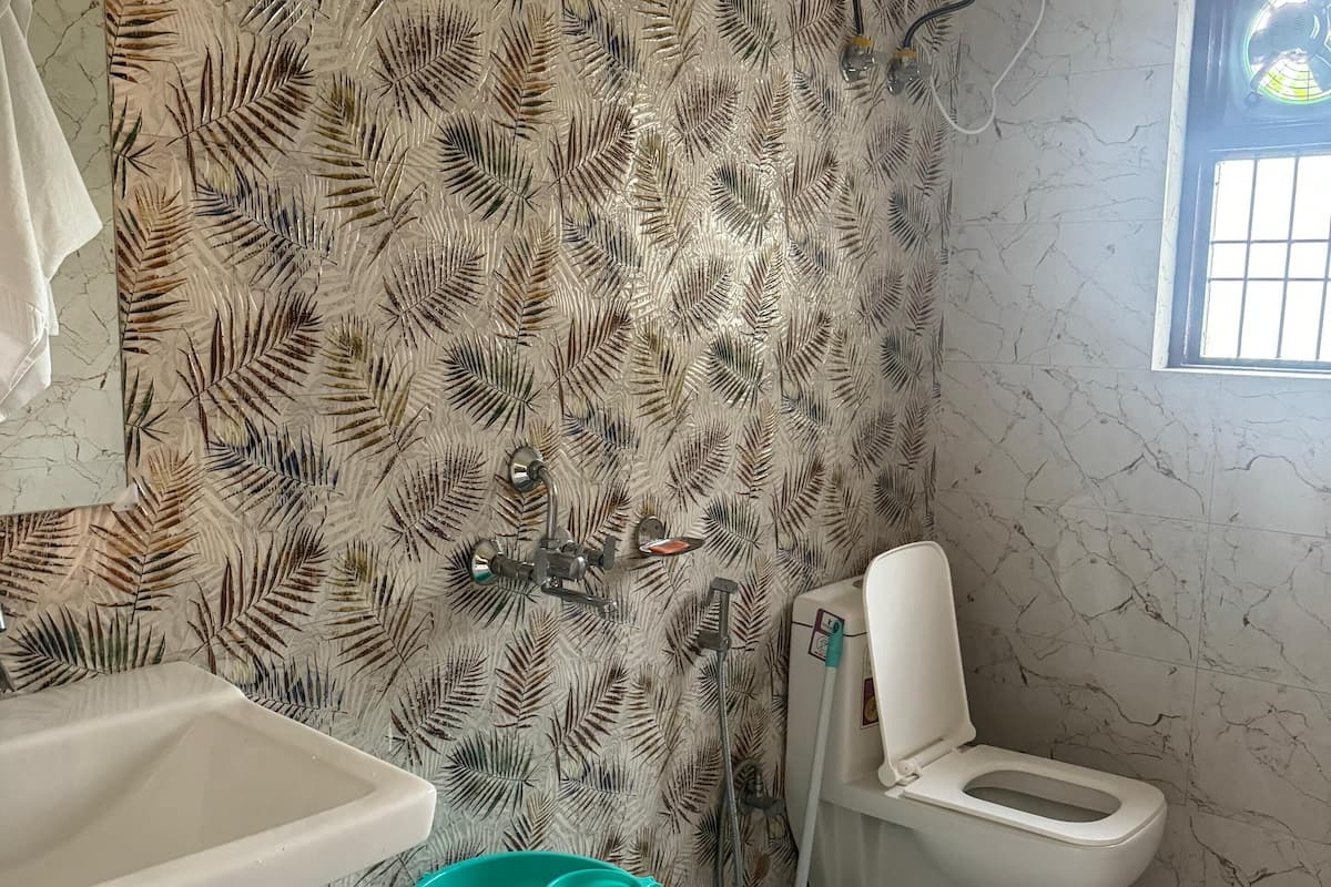 Une salle de bain avec douche, toilettes et lavabo.
