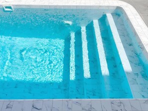 A swimming pool with clear blue water and white tiled edges. - BanyakasSirindhron (Sirindhorn)