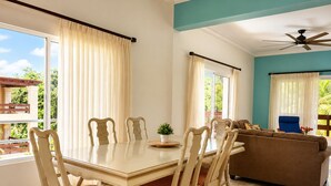 Un espace repas comprenant une table et des chaises, un canapé et un ventilateur de plafond.