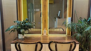 A dining area with a wooden table, two chairs, and a large mirror with arched frames. - Cubicity De Tham (Ho Chi Minh City)
