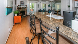 A modern kitchen with granite countertops, a built-in stove, and a bar area with stools. - Bayview Condo (Big Bear Lake)