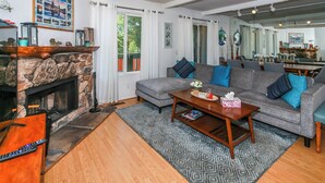 A cozy living room with a fireplace, a grey sofa, and a coffee table. - Bayview Condo (Big Bear Lake)
