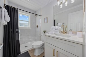 A modern bathroom with a shower, toilet, and vanity.