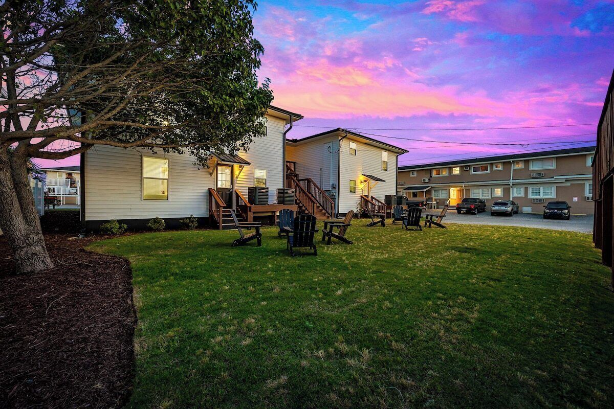 A residential area with houses, a tree, and outdoor seating.