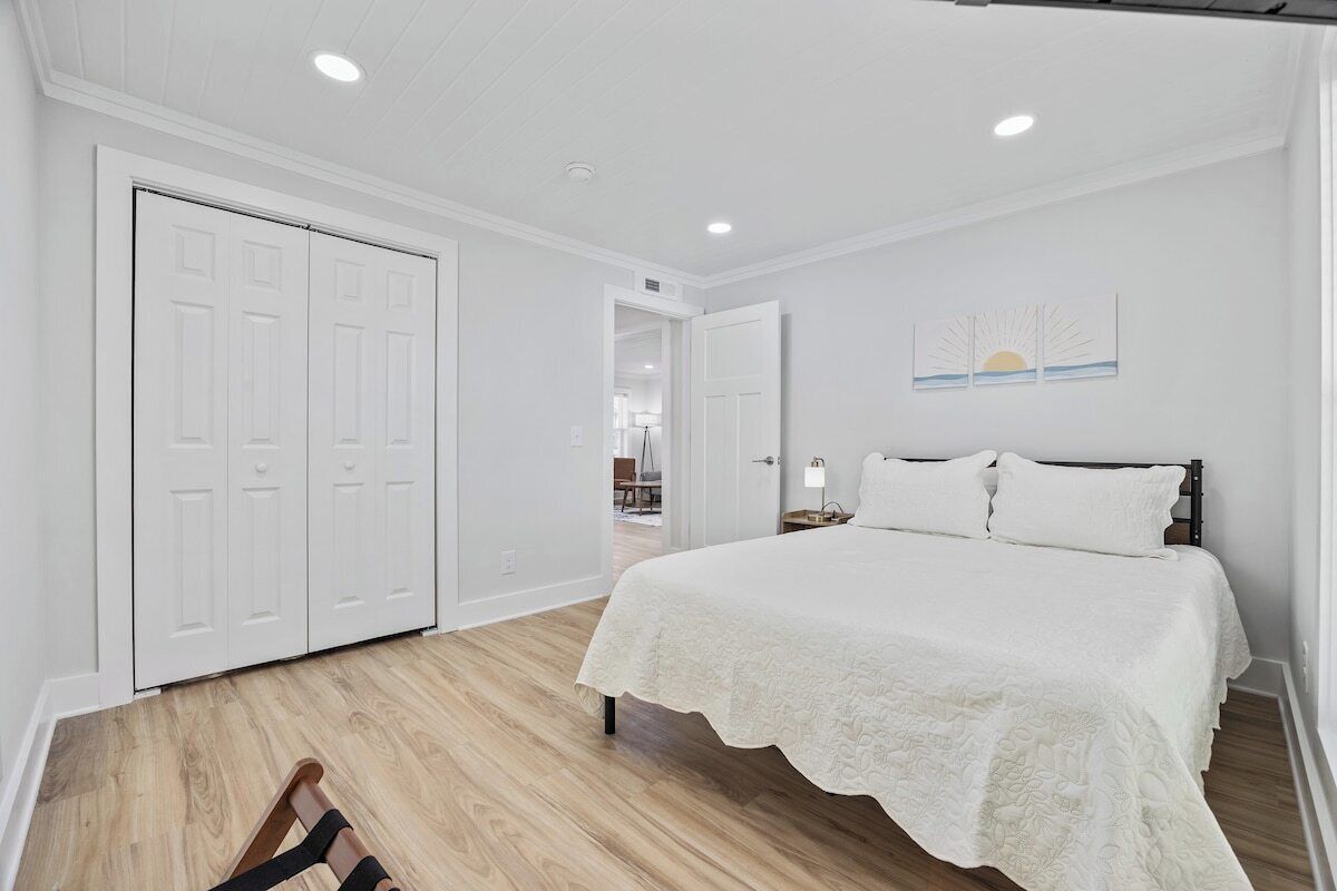A bedroom with a bed, a wardrobe, and a door leading to another room.