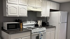 A kitchen with white cabinetry, a stove, a microwave, a refrigerator, and a gas range. - 2-bedroom guest house in charming Cuba with WiFi (Cuba)
