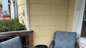 A wooden deck with two metal-framed chairs with patterned cushions, a small round table, and a grey rug. - 2-bedroom guest house in charming Cuba with WiFi (Cuba)