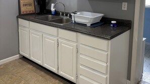 A kitchen with white cabinets, a granite countertop, a double sink, and a framed quote on the wall. - 2-bedroom guest house in charming Cuba with WiFi (Cuba)