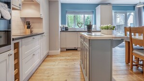 Una cucina moderna con mobili bianchi, un piano di lavoro in legno e una finestra con vista.